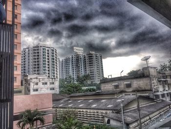 View of cityscape against cloudy sky