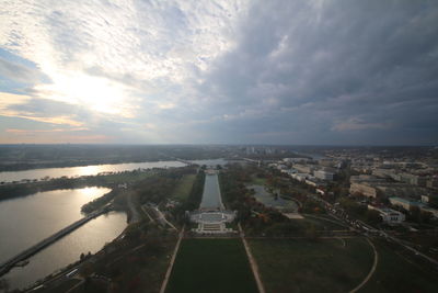 Aerial view of city by sea against sky