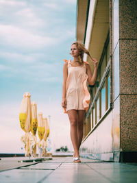 Young woman standing against the sky