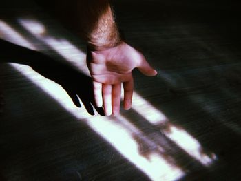 Cropped hand of man reaching hardwood floor at home