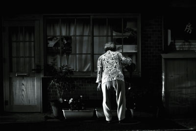 Rear view of woman standing against building