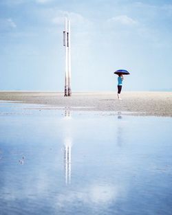 Woman holding umbrella at beach