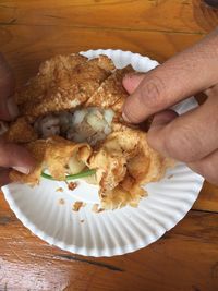 Close-up of hand holding ice cream in plate