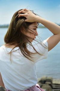 Midsection of woman standing in sea against sky