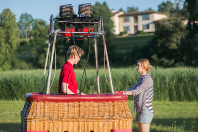 Friends arranging musical equipment against trees