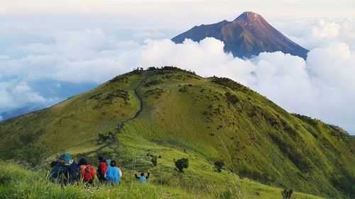 Hikers on mountain against sky