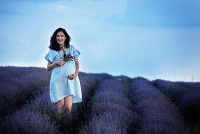 Full length of woman standing on field against sky