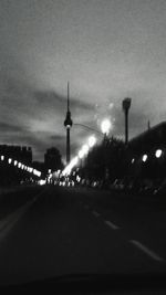 Road passing through illuminated city at night