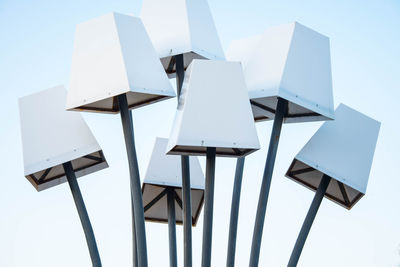 Low angle view of chairs on table against clear sky