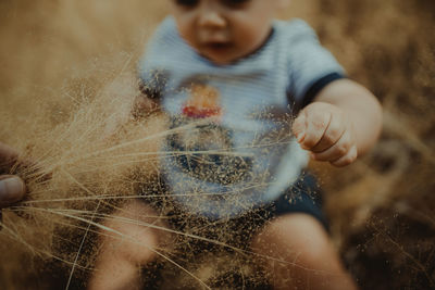 High angle view of cute baby boy sitting on grass