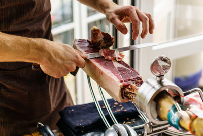 Midsection of man cutting meat