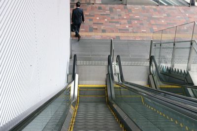 High angle view of man walking on staircase at railroad station