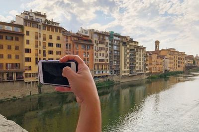 Reflection of person photographing in city