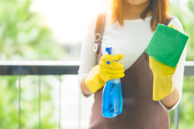 Midsection of woman holding yellow umbrella