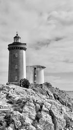 Lighthouse by sea against sky