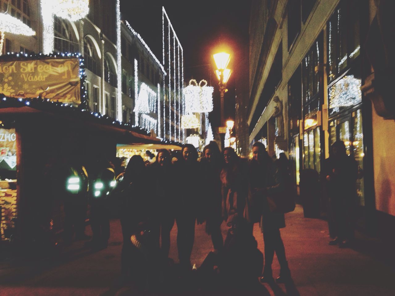 illuminated, night, building exterior, architecture, built structure, men, city, lighting equipment, street, person, lifestyles, large group of people, city life, street light, walking, building, outdoors, leisure activity, incidental people