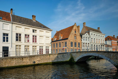 Arch bridge over river against buildings in city