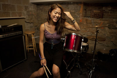 Young woman standing by her drum kit
