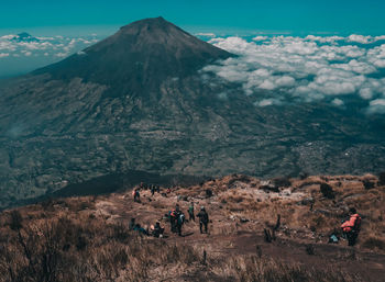 People on mountain range against sky