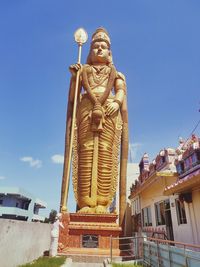 Low angle view of statue against building against sky