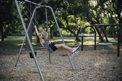 Side view of girl swinging at park