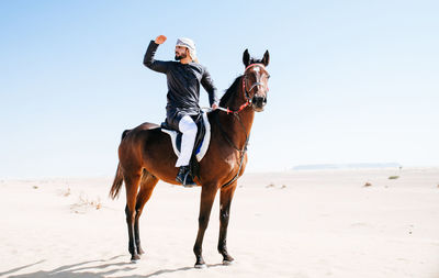 Man riding horse on beach