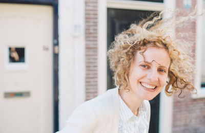 Portrait of smiling woman against house