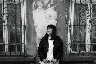 Portrait of a young man standing on railing