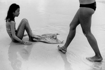 Low section of woman on sand at beach