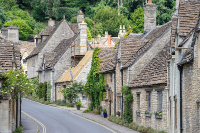 Road amidst trees and buildings in city