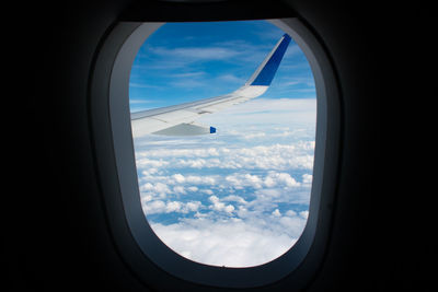 View of cloudy sky seen through airplane window