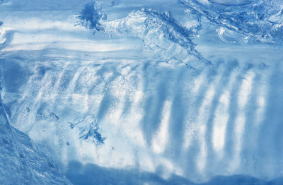 Natural blue blurred background - pattern of the melting ice close-up. selective focus, copy space.