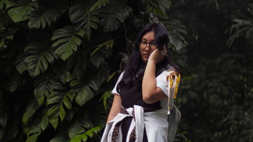 Full length of woman standing against plants