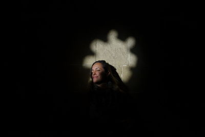 Sunlight falling on mid adult woman in darkroom