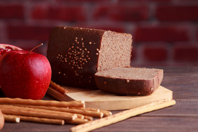 Different buns of fresh bread and spikelets of wheat on a brown vintage background