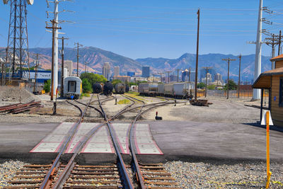 Railroad tracks by mountain against sky