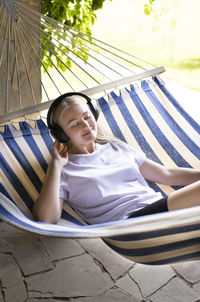 Portrait of smiling young woman sitting on sofa at home