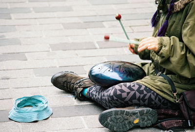 High angle view of man holding cigarette on street