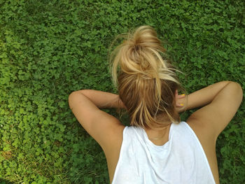 Rear view of woman lying on grass