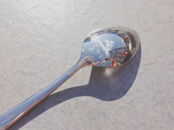 Close-up of buildings reflecting on spoon at table