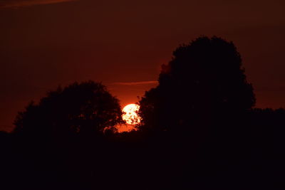 Low angle view of silhouette trees against romantic sky