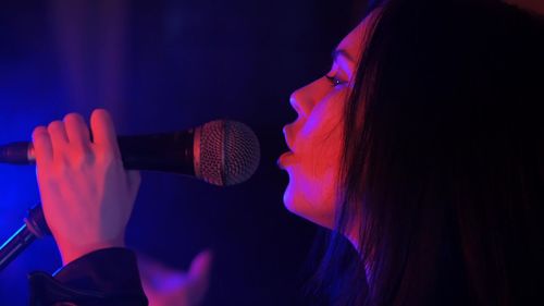 Close-up of woman singing during concert