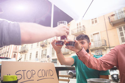 Young man drinking beer in city