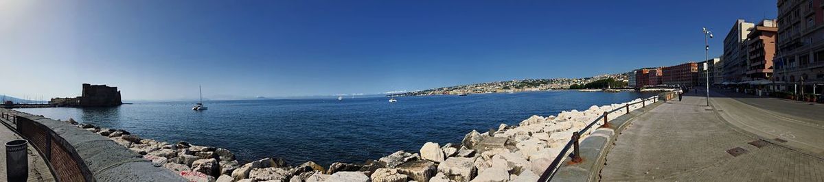 Panoramic view of bay against clear blue sky