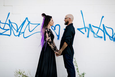 Friends standing against wall