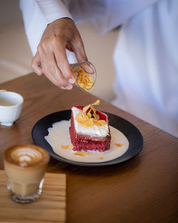 Midsection of man holding ice cream on table