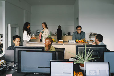 Multiracial corporate business colleagues communicating with each other at office