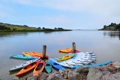 Kayaks moored on beach against sky