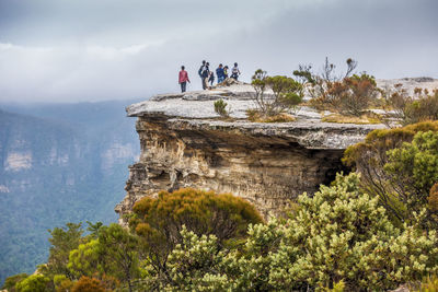 View of people standing on mountain against sky