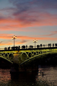 Bridge over river against sky during sunset